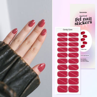 Hand featuring EyeCandys Candy Cane gel nail stickers, with a film displaying the design. Ideal for effortless, trendy nail art with durable, vibrant patterns and a professional finish for at-home manicures