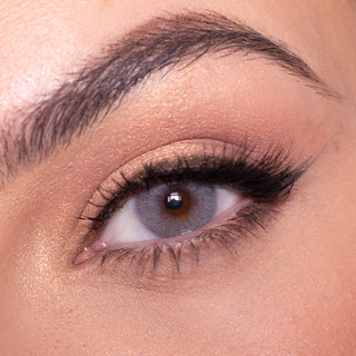 Macro shot of Date to be grey contact lens with intricate spokes design, modelled on a dark brown eye with natural eye makeup