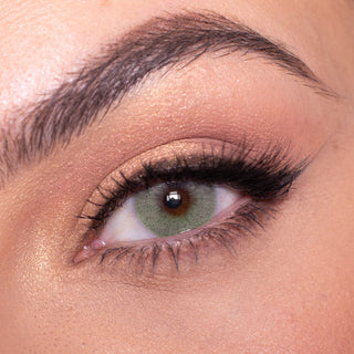 Macro shot of Date to be green contact lens with intricate spokes design, modelled on a dark brown eye with natural eye makeup