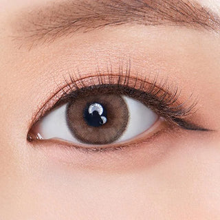 Macro shot of an eye wearing the Olola Dearsome Milk Brown (KR) prescription colour contact lens, showing the multi-colored detail and natural effect on dark brown eyes.