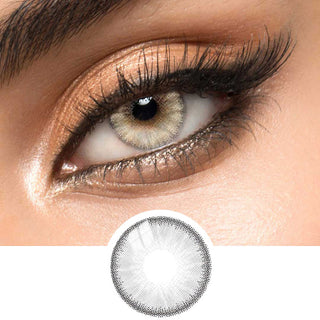 Close-up view of EyeCandys  Desire Innocent White Grey contact lens over a brown iris, demonstrating color transformation paired with natural eye makeup, next to a cutout of the contact lens