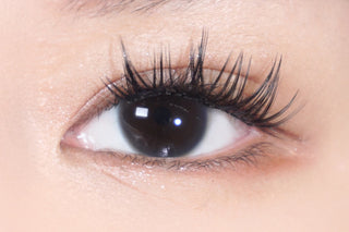 Close-up of natural dark brown eye with wispy lashes – soft, natural look for contact lenses and beauty inspiration