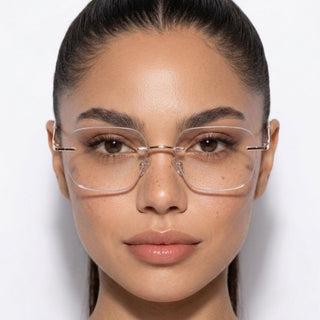 A woman with smooth, pulled-back dark hair wears EyeCandys Dusk Rimless Rectangular minimalist eyewear. She looks directly at the camera against a plain white background, with a neutral expression and clear skin.