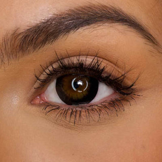 Model with brown eyes showcasing EyeCandys Extra Magic Black prescription colored contact lenses for enhanced eye color and comfort