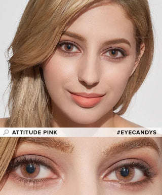 A woman with light brown hair wears pink-toned makeup and soft pink lipstick, complemented by EyeCandys Attitude Glitter Pink colored contacts. Close-up of her face and eyes. Text: "EyeCandys Attitude Glitter Pink" and "#EYECANDYS".