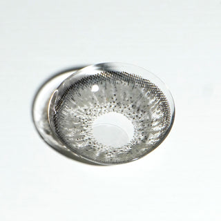 High quality macro shot flatlay of eyelighter grey Contact lens in a plain white backdrop showing the details of the lens