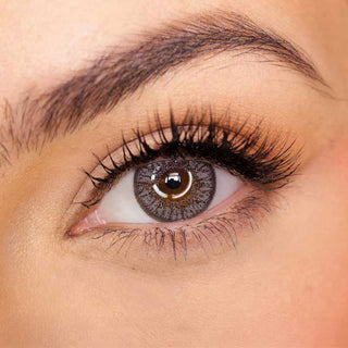 Pink Label Eyelighter Grey color contact lens on top of a dark eye paired with subtle eye makeup and curled wispy eyelashes