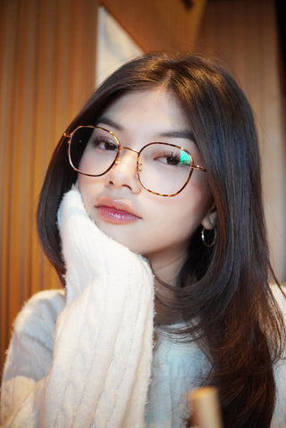 A stylish woman wearing Farrow Round Glasses with a tortoiseshell frame, showcasing a chic and sophisticated eyewear look perfect for everyday fashion.