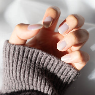 Model's hand showcasing EyeCandys Fiji Girlie Gel Nail Stickers. These iridescent white stickers offer a shimmering, elegant finish, providing a glossy, long-lasting manicure with minimal effort. The soft, radiant hue adds a touch of sophistication and style to any look.