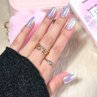 Model's hand showcasing EyeCandys Fiji Gel Nail Stickers. These iridescent white stickers offer a shimmering, elegant finish, providing a glossy, long-lasting manicure with minimal effort. The soft, radiant hue adds a touch of sophistication and style to any look