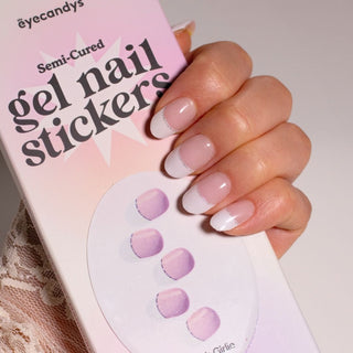 Model's hand showcasing EyeCandys French Girlie Gel Nail Stickers. These stickers feature a classic French tip design with a white top and soft pink bottom, offering a chic and feminine look. The easy-to-apply, long-lasting stickers provide a smooth, glossy finish, perfect for a stylish and elegant manicure