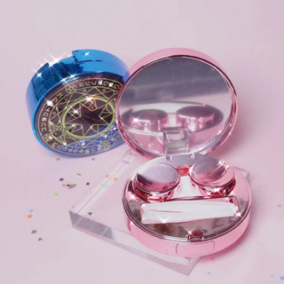 Sailor Moon themed contact lens case in blue and pink. The Pink one is open and shows a compartment for putting in a pair of contact lenses and a rubber ended tweezer tool for handling the contact lens.