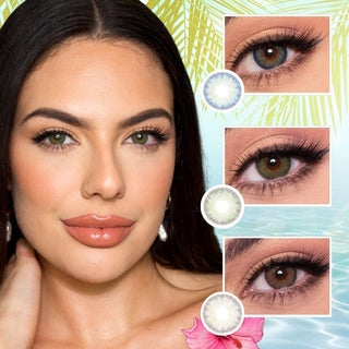 A woman with light skin, dark hair, and green eyes wears neutral makeup with glossy lips. Three close-up images of her eyes showcasing different colored contacts (light blue, green, and gray) from the EyeCandys Isla Set (3 Pairs) by EyeCandys are displayed next to her face. The background evokes tropical paradises with palm leaves and flowers.