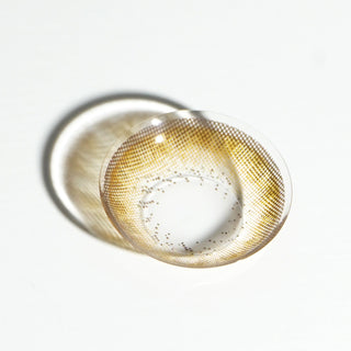 High quality macro shot flatlay of juju brown Contact lens in a plain white backdrop showing the details of the lens