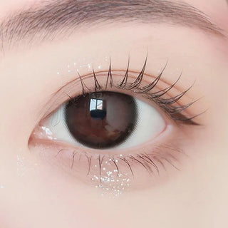 Close-up of model's eye wearing with Ann365 JUST MAX Black Korean color contact lens with prescription, complemented with barely there eye makeup, showing the brightening and enlarging effect of the circle lens on dark brown eyes.