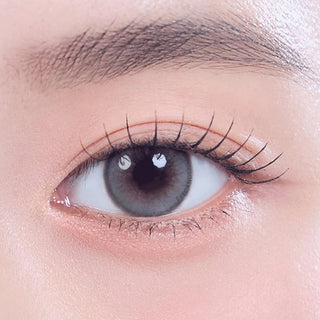 Close-up shot of model's eye adorned with Gemhour Khione 1-Day Grey (10pk) color contact lenses with prescription, complemented by minimalist eye makeup, showing the brightening and enlarging effect of the circle contact lens on dark brown eyes.