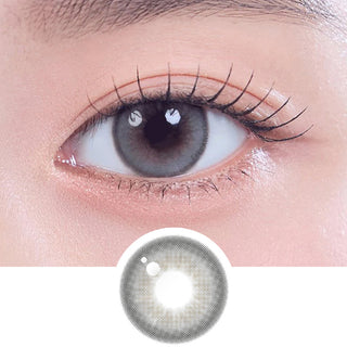 Close-up shot of model's eye adorned with Gemhour Khione 1-Day Grey (10pk) daily color contact lenses with prescription, complemented by clean eye makeup, showing the brightening and enlarging effect of the circle contact lens on dark brown eyes, above a cutout of the contact lens pattern with limbal ring on a white background.