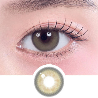Close-up shot of model's eye adorned with Gemhour Khione 1-Day Olive (10pk) daily color contact lenses with prescription, complemented by clean eye makeup, showing the brightening and enlarging effect of the circle contact lens on dark brown eyes, above a cutout of the contact lens pattern with limbal ring on a white background.