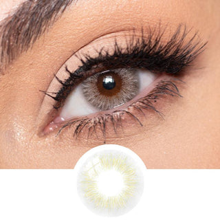 Close up of the Los Angeles Grey colour contact lens on a model's eye with minimal eye makeup and long lashes, available in prescription, above a cutout of the grey prescription color contact lens itself
