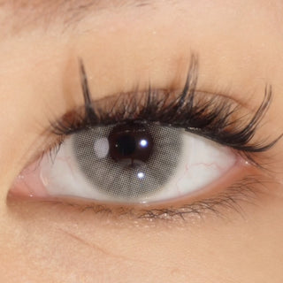 Close-up of an eye wearing EyeCandys Glossy Ivory prescription colored contact lenses and Hasom Luxury 06 pre-glued cluster lashes for a bright-eyed look with defined, voluminous lashes.