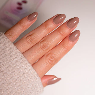 Model's hand showcasing EyeCandys Macchiato Gel Nail Stickers. These warm, coffee-inspired stickers feature a rich, neutral tone with a glossy finish, offering a sophisticated, long-lasting, chip-free manicure