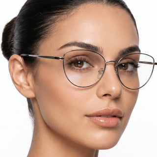 A woman with smooth skin and brown eyes wears EyeCandys Madame Cat Eye lightweight metal frames. Her dark hair is pulled back neatly, she has a neutral expression, and the background is white.
