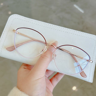 Hand holding EyeCandys Madame prescription glasses, available in blue light blocking, Zeiss HMC, and photochromic lenses for ultimate eye protection