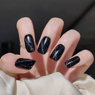 Hand with EyeCandys Meow Me Back Gel nail stickers applied, featuring a sleek black color with glitter accents. Perfect for edgy, glamorous manicures, offering long-lasting wear, easy application, and a sparkling, salon-quality gel finish for eye-catching nails.