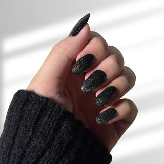 Hand with EyeCandys Meow Me Back Gel nail stickers applied, featuring a sleek black color with glitter accents. Perfect for edgy, glamorous manicures, offering long-lasting wear, easy application, and a sparkling, salon-quality gel finish for eye-catching nails.