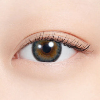 Close-up of eye wearing EyeCandys N's Collection Lassie Neo Grey (10pk) prescription colored contact lens, bright silver grey iris with green shimmer and dark limbal ring, Korean daily disposable contact lens for striking yet natural eye color transformation