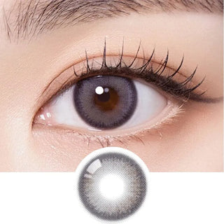 Macro shot of an eye wearing the Olola Muted Grey colour contact lens, showing the multi-colored detail and natural effect on dark brown eyes, with clean eye makeup