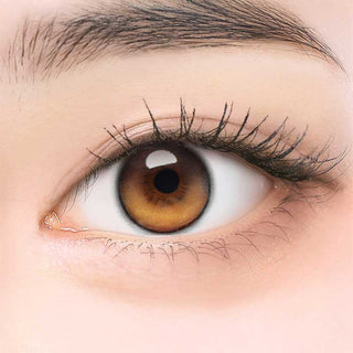 Close-up of model's eye wearing EyeCandys ONE PICK Balance Golden Hour prescription contact lens, enhancing eye color with a warm golden tone for clear vision and all-day comfort