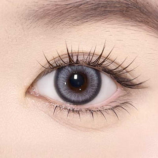 Olala Meow Burman Grey color contact lens on top of a dark eye paired with subtle eye makeup and curled wispy eyelashes,