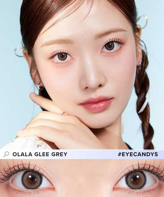 A female model with natural dark eyes wearing Olala Glee Grey contact lenses, complemented by subtle eyeshadow and peach lipstick and Close-up image showcases the model's eyes adorned with the same Grey contact lenses