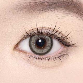 Olala Meow Rubl Green color contact lens on top of a dark eye paired with subtle eye makeup and curled wispy eyelashes