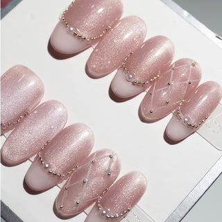 Close-up of EyeCandys Ballet Slippers press on nails on a white background featuring soft nude ballet pink tones with glossy finish, quilted texture, pearl accents, and subtle French tips.