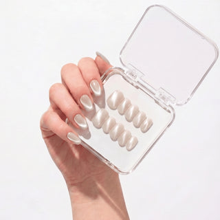 Hand wearing EyeCandys Moon Syrup press on nails with semi-sheer jelly nude base and soft pearly cat-eye glow.