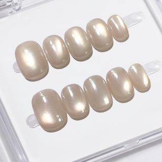 Close-up of EyeCandys Moon Syrup press on nails featuring semi-sheer jelly nude tone with soft pearly cat-eye glow on a white background.