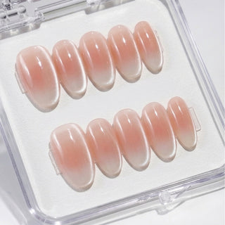 Close-up of EyeCandys Cloud Nine press on nails featuring milky white baby boomer gradient with velvety cat-eye shimmer and soft magnetic glow on a white background.