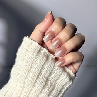 Hand showcasing EyeCandys Cloud Nine press on nails featuring soft milky white gradient and ethereal cat-eye finish.