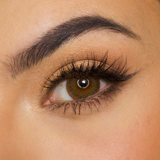 Pink Label vintage Brown color contact lens on top of a dark eye paired with subtle eye makeup and curled wispy eyelashes