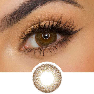 Pink Label Vintage Brown color contact lens on top of a dark eye paired with subtle eye makeup and curled wispy eyelashes, above the contact lens design.
