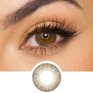 Pink Label Vintage grey color contact lens on top of a dark eye paired with subtle eye makeup and curled wispy eyelashes, above the contact lens design.
