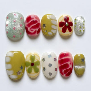 Pucker Up Press-On Nails by EyeCandys features ten colorful, reusable handmade nails with polka dots, wavy lines, flowers, stars, and hexagons in green, red, yellow, white, and silver—perfect for a salon-quality gel manicure at home.