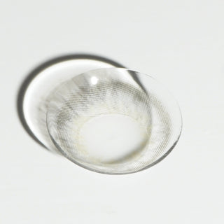 High quality macro shot flatlay of EyeCandys Sugarlook Grey Contact lens in a plain white backdrop showing the details of the lens