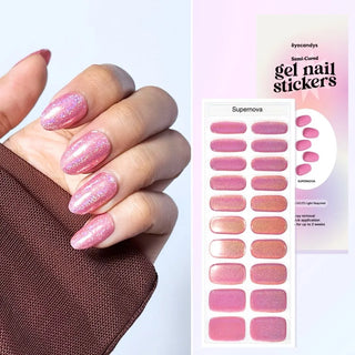 Hand featuring EyeCandys Supernova Gel Nail Stickers – high-shine, glittery pink gel nail wraps for an effortless, professional manicure