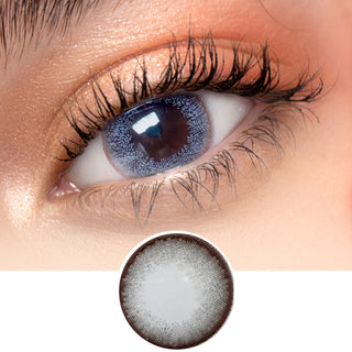 Close-up image showcasing the Toronto Grey contact lens on a white surface, featuring a model with dark brown eyes and natural eye makeup. The image also includes a cutout of the contact lens.