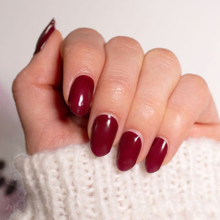 Model's hand showcasing EyeCandys Wine Not Gel Nail Stickers with a rich wine-colored design. These easy-to-apply, long-lasting gel stickers offer a chic, chip-free finish, perfect for a stylish, effortless manicure.