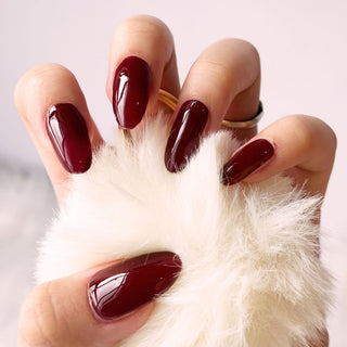 Hand with EyeCandys Wine Me Not Gel nail stickers applied, showcasing a deep red color. Perfect for elegant, bold manicures, offering long-lasting wear, easy application, and a smooth, salon-quality gel finish for stunning, polished nails