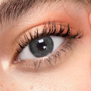 Close up shot of a model with natural dark eyes wearing EyeCandys Pink Label Angel Grey colored contact lens complemented by natural eye make up 